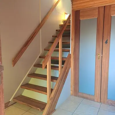 a wooden staircase in a room with a door at Villa Tehillah in Dullstroom