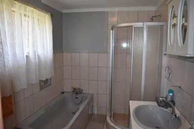 a bathroom with a bath tub and a sink at Villa Tehillah in Dullstroom