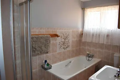 a bathroom with a bath tub and a sink at Villa Tehillah in Dullstroom