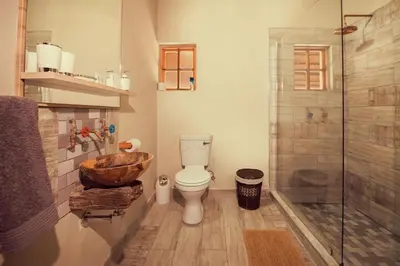 a bathroom with a toilet and a glass shower at Hayoma Lodge in Tshipise
