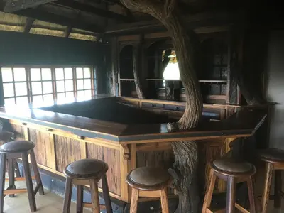 a wooden bar with stools around it at Hayoma Lodge in Tshipise