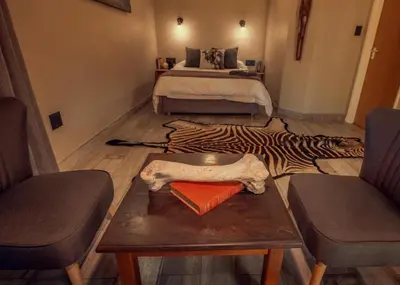 a living room with a bed and a zebra rug at Hayoma Lodge in Tshipise