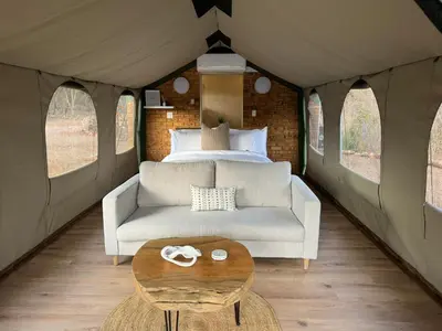 a room with a couch and a bed and a table at Vrede Luxury Tented Camp in Kosmos