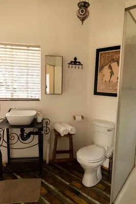 a bathroom with a white toilet and a sink at Camellia Luxury Apartment in Pretoria