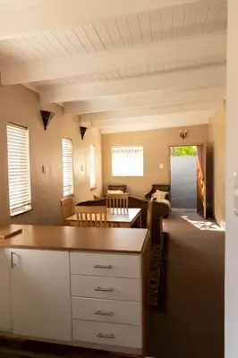 a kitchen and living room with a table and chairs at Camellia Luxury Apartment in Pretoria