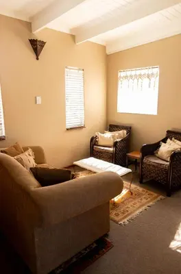 a living room with a couch and two chairs at Camellia Luxury Apartment in Pretoria