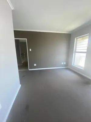 an empty living room with a window and a white wall at Ore Private property in Midrand