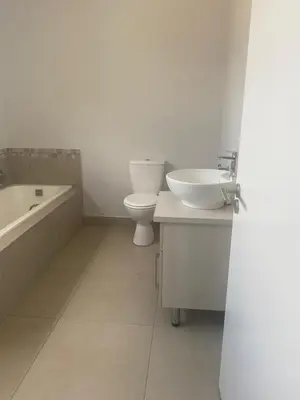 a bathroom with a sink and a toilet and a tub at Ore Private property in Midrand