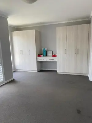 an empty room with white cabinets and a microwave at Ore Private property in Midrand