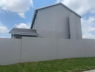 a white building behind a white fence at Ore Private property in Midrand
