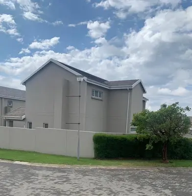 a white house with a fence and a tree at Ore Private property in Midrand
