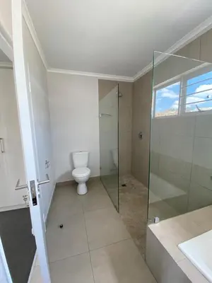 a bathroom with a toilet and a glass shower at Ore Private property in Midrand