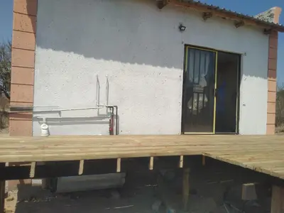 a wooden deck in front of a house at PK house in Mbabat