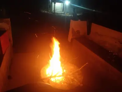 a fire is burning in a room at night at PK house in Mbabat