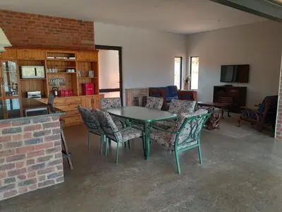 a living room with a table and chairs at Elements Golfers Lodge 123 in Moheme