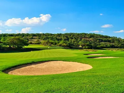 a view of a green golf course with a bunker at Elements Golfers Lodge 123 in Moheme