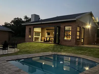a house with a swimming pool in the yard at Elements Golfers Lodge 123 in Moheme