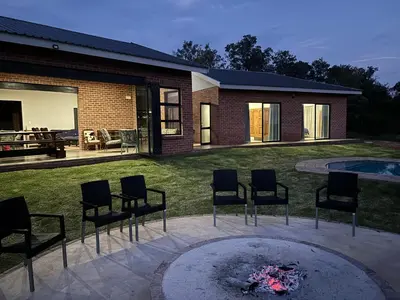 a patio with chairs and a fire pit in a yard at Elements Golfers Lodge 123 in Moheme