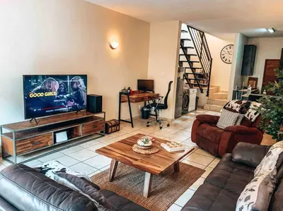 a living room with a couch and a tv at Luxury Duplex in Pretoria East in Pretoria