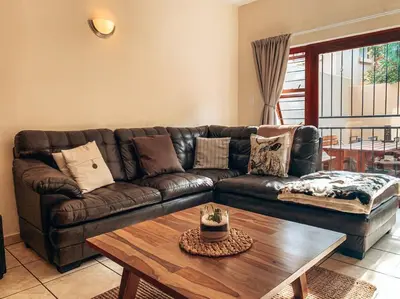 a living room with a leather couch and a coffee table at Luxury Duplex in Pretoria East in Pretoria
