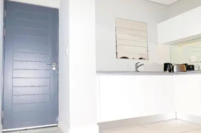 a blue door in a kitchen next to a sink at The Thorn by the airport in Kempton Park