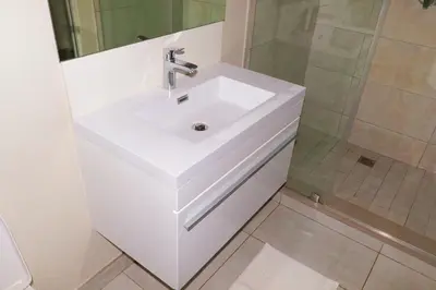 a bathroom with a white sink and a shower at The Thorn by the airport in Kempton Park