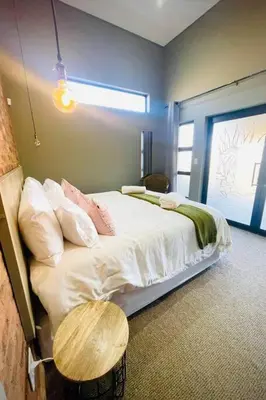 a bedroom with a bed with a table in it at Highland Peace Haven In Dullstroom in Dullstroom