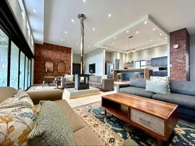 a living room with a couch and a table at Highland Peace Haven In Dullstroom in Dullstroom