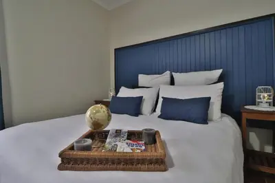 a bed with a blue headboard and a tray on it at Crowley Cottage in White River