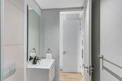 a white bathroom with a sink and a mirror at 2 Bed Luxury Apartment, Ellipse, Waterfall in Midrand