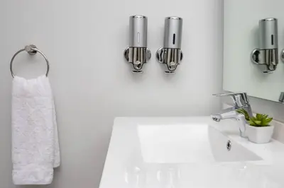 a bathroom with a sink and two candles on the wall at 2 Bed Luxury Apartment, Ellipse, Waterfall in Midrand