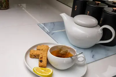 a plate with a cup of tea and biscuits and a teapot at 2 Bed Luxury Apartment, Ellipse, Waterfall in Midrand