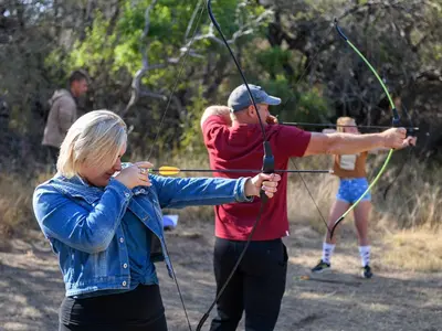 a man and a woman holding a bow and arrow at Dikhololo in Brits