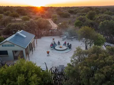 a group of people sitting around a fountain at sunset at Dikhololo in Brits
