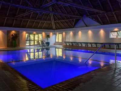 a pool with blue lighting in a building at Dikhololo in Brits