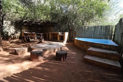 a backyard with a pool and a table and trees at Mbaula lodge in Letaba Wildlife Reserve