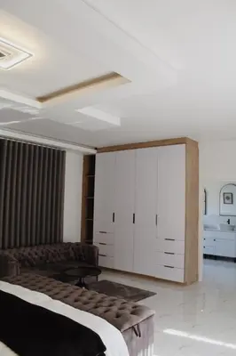 a bedroom with a bed and a large white cabinet at Kingdoms Lodge in Groblersdal