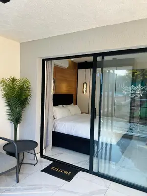 a bedroom with a bed and a sliding glass door at Kingdoms Lodge in Groblersdal