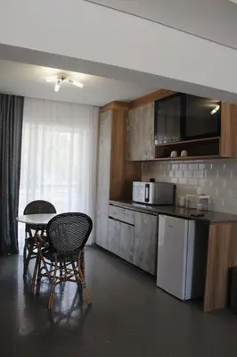 a kitchen with a table and two chairs and a counter at Kingdoms Lodge in Groblersdal