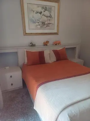 a bedroom with a bed with an orange blanket at Countrylane Lodge in Midrand