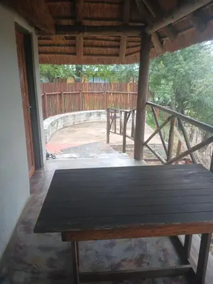 a wooden bench in a porch with a fence at Mbaula lodge in Letaba Wildlife Reserve