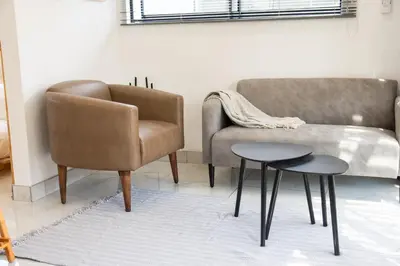 a living room with a couch and a chair and a table at Cozy Box Haus in Graskop