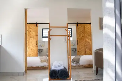 a mirror in a room with two beds at Cozy Box Haus in Graskop