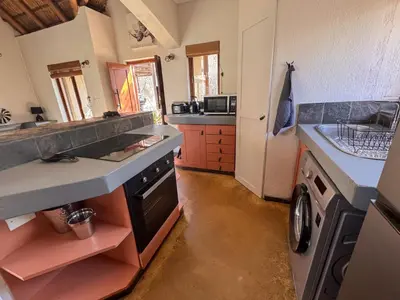 a kitchen with a sink and a stove top oven at Raptors Lodge - NXALATI in Hoedspruit