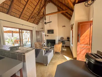 a living room with a couch and a table at Raptors Lodge - NXALATI in Hoedspruit