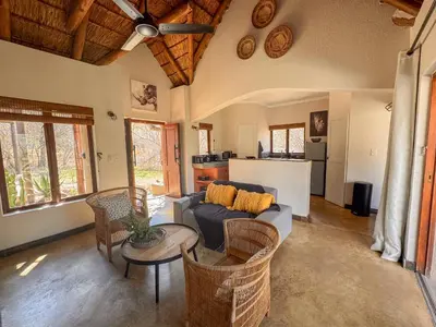 a living room with a couch and a table at Raptors Lodge - NXALATI in Hoedspruit
