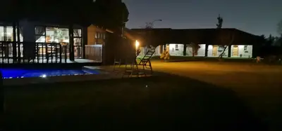 a couple of chairs sitting in a yard at night at Malikana Guesthouse in Kempton Park