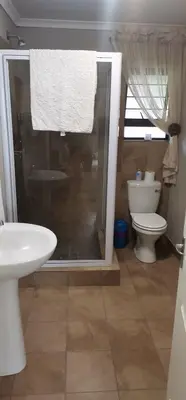 a bathroom with a shower and a sink and a toilet at Malikana Guesthouse in Kempton Park
