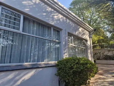 a house with windows and a bush in front of it at Amen guest apartment in Pretoria