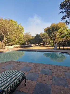 a swimming pool with a bench in front of it at Amen guest apartment in Pretoria